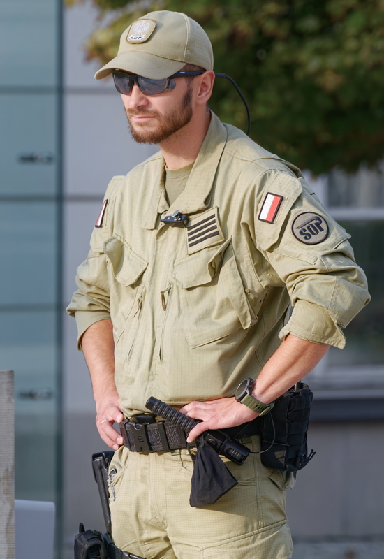 9 - A member of the Polish State Protection Service  wearing a tan combat uniform and cap